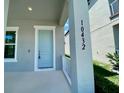Light blue front door with a white trim and a gray porch at 10432 Austrina Oak Loop, Winter Garden, FL 34787