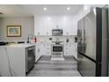 Well-lit kitchen with white cabinetry, stainless steel appliances, and modern countertops at 219 Plumoso Loop, Davenport, FL 33897