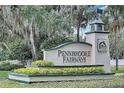 A welcoming Pennbrooke Fairways community sign surrounded by lush landscaping and mature trees at 228 Westwood Dr, Leesburg, FL 34748