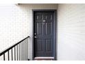 Condo building entry with dark gray door and brick wall at 3700 Idlebrook Cir # 208, Casselberry, FL 32707