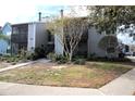 Two-story condo building with gray and blue siding, walkway, and landscaping at 3700 Idlebrook Cir # 208, Casselberry, FL 32707