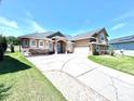 Beautiful single-Gathering home with lush green lawn, stone accents, and an expansive driveway at 5210 Sailwind Cir, Orlando, FL 32810
