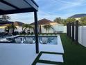 Luxury pool area with lounge chairs, a pergola, and modern landscaping at 526 First Cape Coral Dr, Winter Garden, FL 34787