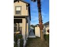Landscaped side yard with a walkway leading to a gate and a palm tree at 526 First Cape Coral Dr, Winter Garden, FL 34787