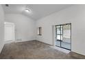 Spacious living room with vaulted ceiling, neutral walls, and sliding glass doors to patio at 7416 Windsome Ct, Orlando, FL 32810