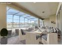 Screened-in patio featuring comfortable seating arrangements and scenic views of the tranquil lake at 8833 Corcovado Dr, Kissimmee, FL 34747