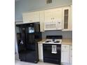 Black appliances and white cabinets in this bright kitchen at 89 Crooked Pine Rd, Port Orange, FL 32128