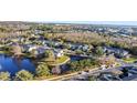 Aerial view of townhouses, pond, and surrounding landscape at 9746 Tiramasu Trl, Orlando, FL 32829