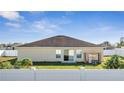 View of the back of house with a white fence, a yard, and sliding glass doors at 1317 Conch Key Ln, Davenport, FL 33837