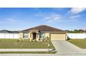 Inviting one-story home with manicured lawn, an attached garage, and a neatly maintained exterior at 1317 Conch Key Ln, Davenport, FL 33837