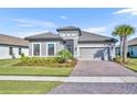 Charming single-story home with a tile roof, paver driveway, well-manicured lawn, and lush landscaping at 1511 Goblet Cove St, Kissimmee, FL 34746
