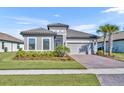 Charming single-story home with a tile roof, paver driveway, well-manicured lawn, and lush landscaping at 1511 Goblet Cove St, Kissimmee, FL 34746