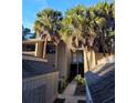 Exterior view of condo building showcasing a walkway, landscaping, and private storage units at 203 Crown Oaks Way # 202, Longwood, FL 32779