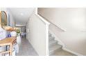 Modern staircase with neutral carpeting and tile flooring in hallway at 2183 Longleaf Rd, Davenport, FL 33837