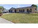 Well-maintained single-story home showcasing a green lawn, brick driveway, and attached garage at 2537 Lanier Rd, Kissimmee, FL 34744