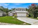 Two-story house with gray siding, brick accents, and a well-maintained lawn at 377 River Chase Dr, Orlando, FL 32807