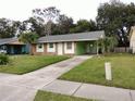 Single story home with stone facade, front lawn, and covered parking area at 417 Benita St, Kissimmee, FL 34744