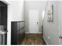 Bright entryway with wood-look flooring, white door, and shoe storage at 494 Amadoras Way, St Cloud, FL 34771