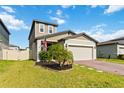 Charming two-story home featuring a brick driveway and attached two-car garage with a well manicured lawn at 494 Amadoras Way, St Cloud, FL 34771