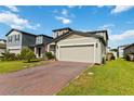Charming two-story home featuring a brick driveway and attached two-car garage with a well manicured lawn at 494 Amadoras Way, St Cloud, FL 34771