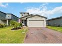 Charming two-story home featuring a brick driveway and attached two-car garage with a well manicured lawn at 494 Amadoras Way, St Cloud, FL 34771