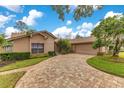 Tan house with a two-car garage and a nicely landscaped yard at 615 Tuskawilla Point Ln, Winter Springs, FL 32708