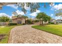 Tan house with a paved driveway and landscaping. Nice curb appeal! at 615 Tuskawilla Point Ln, Winter Springs, FL 32708