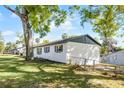 The backyard of the white brick home features a fence, mature trees, and lush greenery at 720 Jasmine Ave, Orange City, FL 32763