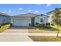 New home exterior with gray siding, two-car garage, and well-maintained lawn at 841 Teton St, Haines City, FL 33844