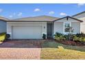 Gray house with a two-car garage and nicely landscaped yard at 841 Teton St, Haines City, FL 33844