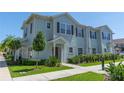 Two story light blue townhome with landscaping at 8923 Shine Dr, Kissimmee, FL 34747