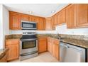 Well-equipped kitchen featuring stainless steel appliances and wood cabinetry at 90 Moree Loop # 15, Winter Springs, FL 32708