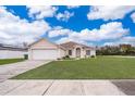 Single-story home with a lush green lawn, white garage door, and inviting front entrance at 1101 James Ave, Deltona, FL 32738