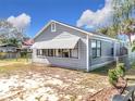 Gray house with awning windows, chain link fence, and American flag visible at 1119 Pine Ave, Tavares, FL 32778