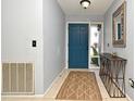 Bright entryway with a blue door, tile floor, and a stylish console table at 127 Kaywood Dr, Sanford, FL 32771