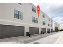 Rear view of townhomes showcasing individual garages at 12964 Brandon Coates Dr, Orlando, FL 32828