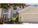 Two-story house with beige exterior, double door entry, and landscaping at 13214 Meergate Cir, Orlando, FL 32837