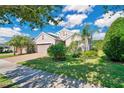 Landscaped home exterior with brick driveway and lush green lawn at 305 Silver Maple Rd, Groveland, FL 34736