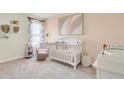 Charming Bedroom featuring a crib, armchair, and changing station at 316 Pelham Park Dr, Deland, FL 32720