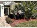 Landscaped entryway with a white pergola and tropical plants at 5114 Jareds Landing Way, Oxford, FL 34484