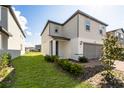 Two-story home with a two-car garage and a green lawn in a modern neighborhood at 581 Sun Warbler Way, St Cloud, FL 34771