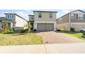 Two-story home with a two-car garage and well-manicured lawn in a modern neighborhood at 581 Sun Warbler Way, St Cloud, FL 34771