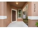 Front entry with brown door, sidelights and a covered porch at 6370 Golden Dewdrop Trl, Windermere, FL 34786