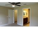 Spacious bedroom with neutral walls, carpeting, ceiling fan, and en-suite bathroom access at 7080 Hemlock Crse, Ocala, FL 34472