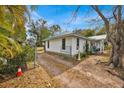 White single-story home with a green roof, side yard, and a chain-link fence at 750 S Dudley Ave, Bartow, FL 33830