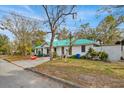 House exterior showcasing a white home with a green roof, mature trees, and a mailbox at 750 S Dudley Ave, Bartow, FL 33830