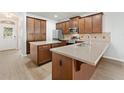Spacious kitchen featuring wood cabinetry, stainless steel appliances, an island, and tile backsplash at 7525 Azalea Cove Cir, Orlando, FL 32807
