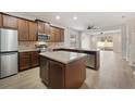 Modern kitchen featuring stainless steel appliances, a center island, and light wood flooring at 7525 Azalea Cove Cir, Orlando, FL 32807