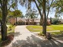 Charming home featuring a brick and stucco facade, lush lawn, and inviting front porch seating at 8620 Willow Kane Ct, Orlando, FL 32835