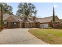 Charming home featuring a brick and stucco facade, lush lawn, and inviting front porch seating at 8620 Willow Kane Ct, Orlando, FL 32835